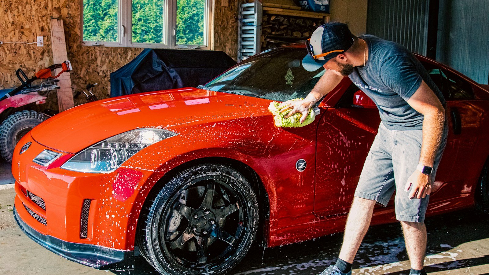 A red sports car being cleaned in a garage, illustrating careful car washing